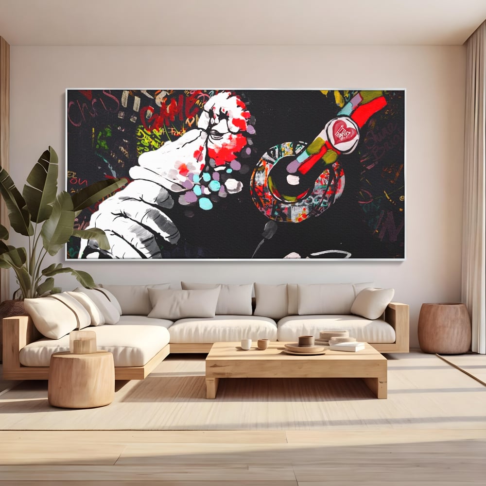 Tablou canvas cu tablou canvas cu maimuta dj, in rama de aluminiu argintiu, pe perete intr-un living